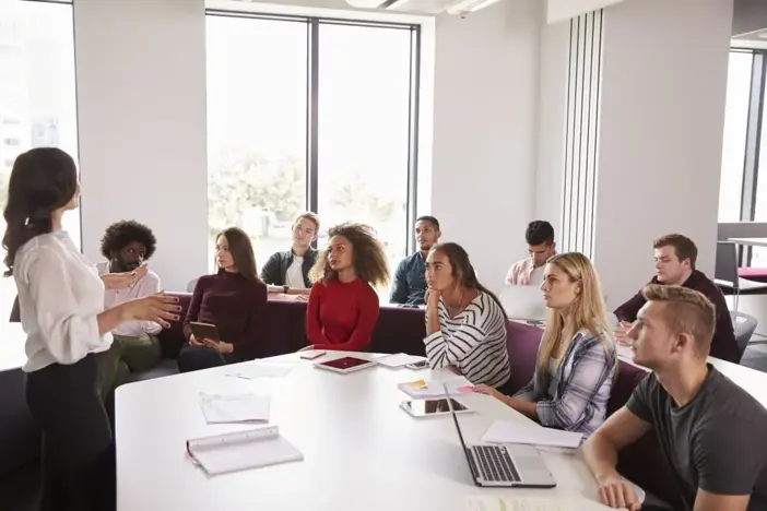 Group Of University Students taking notes with laptops and tablets